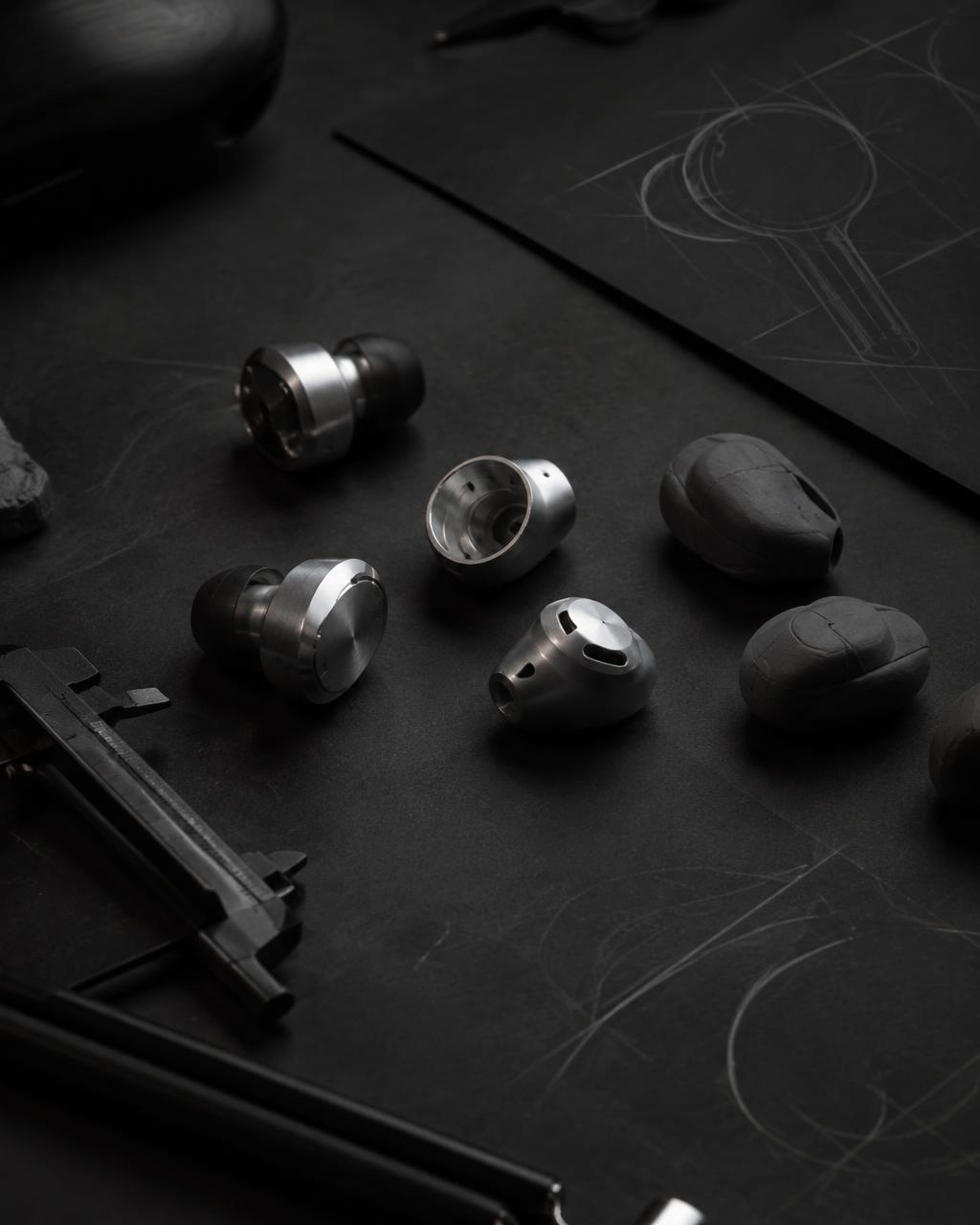 Machined housing prototypes and clay models on a design table